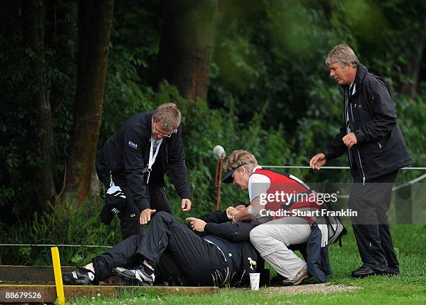 An injured woman recieves attention after breaking her leg infront of players on the seventh hole during the first round of The BMW International...