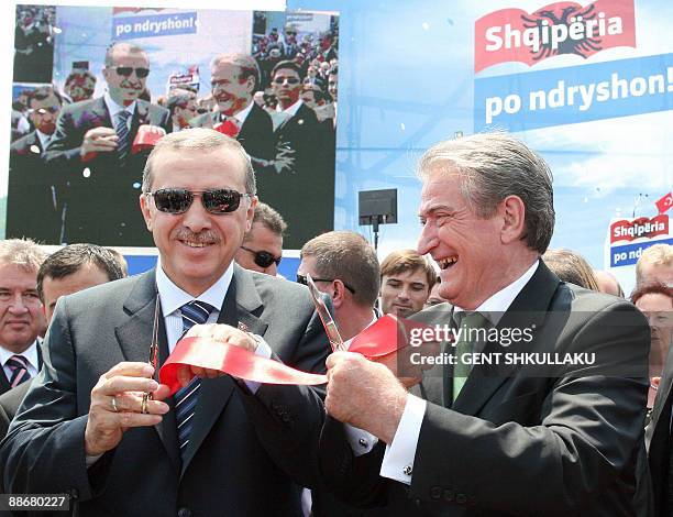Albania's Prime Minister Sali Berisha and his Turkish counterpart Tayyip Erdogan cut the ribbon during the inauguration of a highway connecting...