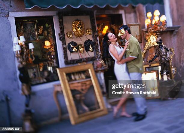 couple shopping for mask in campo santo stefano, venice, italy - maschera veneziana foto e immagini stock