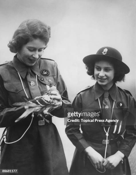 Princess Elizabeth and her younger sister Princess Margaret Rose prepare to release a carrier pigeon with a message to Chief Guide Lady Olave...