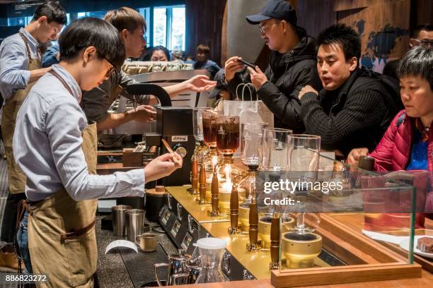 Visitors wait for their coffee at the Starbucks Reserve Roastery outlet in Shanghai on December 6, 2017. Starbucks opened its largest cafe in the...