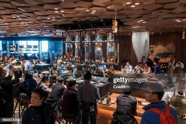 Visitors wait for their coffee at the Starbucks Reserve Roastery outlet in Shanghai on December 6, 2017. Starbucks opened its largest cafe in the...