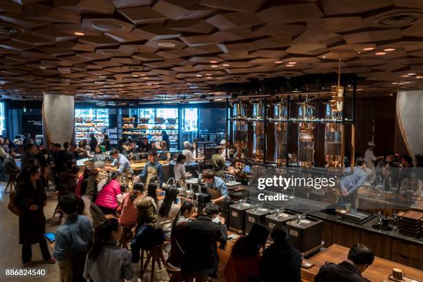 Visitors wait for their coffee at the Starbucks Reserve Roastery outlet in Shanghai on December 6, 2017. Starbucks opened its largest cafe in the...