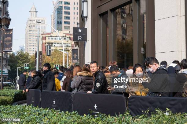 Visitors wait to enter the Starbucks Reserve Roastery outlet in Shanghai on December 6, 2017. Starbucks opened its largest cafe in the world in...