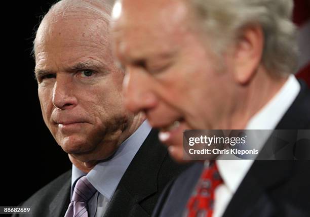 Senator John McCain listens to Senator Joe lieberman speak during a news briefing June 25, 2009 on Capitol Hill in Washington, DC. McCain has...