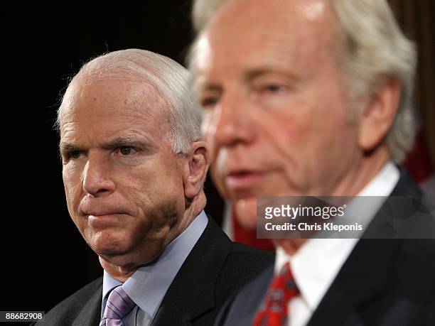 Senator John McCain listens to Senator Joe lieberman speak during a news briefing June 25, 2009 on Capitol Hill in Washington, DC. McCain has...