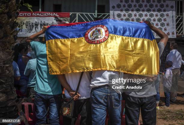 Local children of Guerima hold a flag of Colombia during a notification in Vichada, Colombia on December 05, 2017. Locals of Guerima follow the...