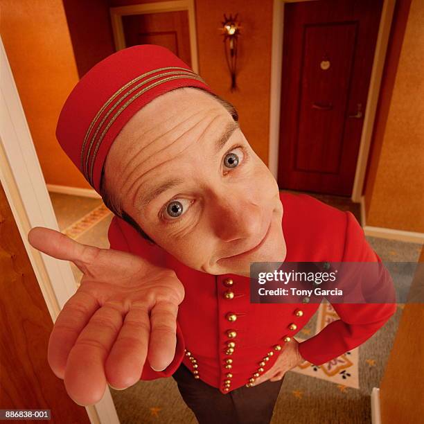 bellboy standing in doorway with hand out (digital composite) - porter foto e immagini stock
