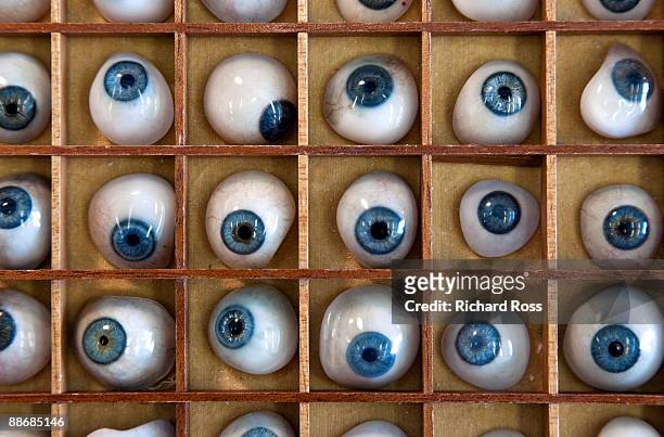 a collection of blue prosthetic eyes - blaues auge stock-fotos und bilder