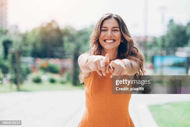 playful beauty - orange dress stock pictures, royalty-free photos & images