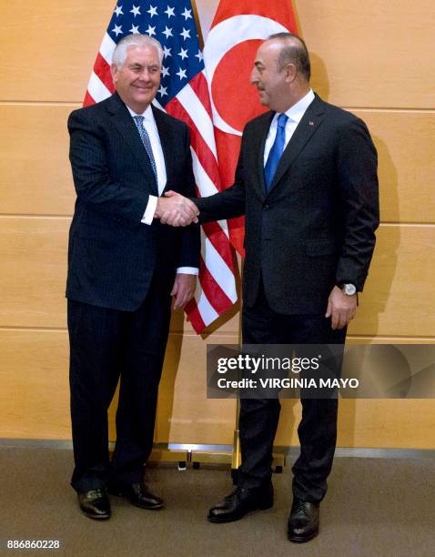 Turkish Foreign Minister Mevlut Cavusoglu shakes hands with US Secretary of State Rex Tillerson before a bilateral meeting on the sidelines of a NATO...