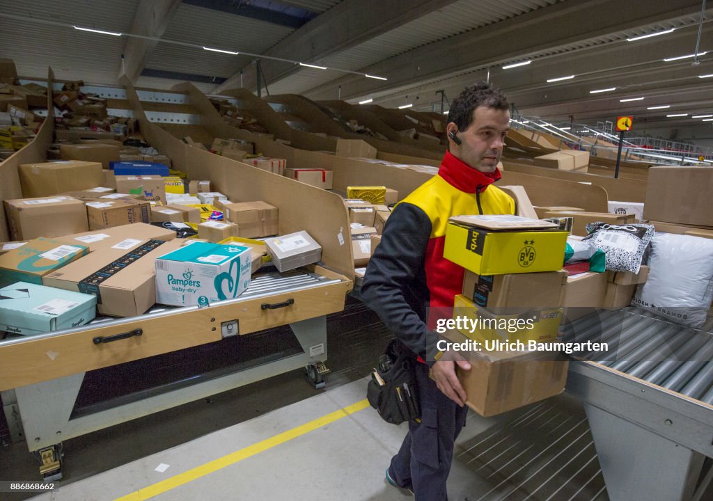 Pre-Christmas operation in the mechanical extradition base of the German Post DHL Group in Cologne. DHL employees sort packages for extradition.