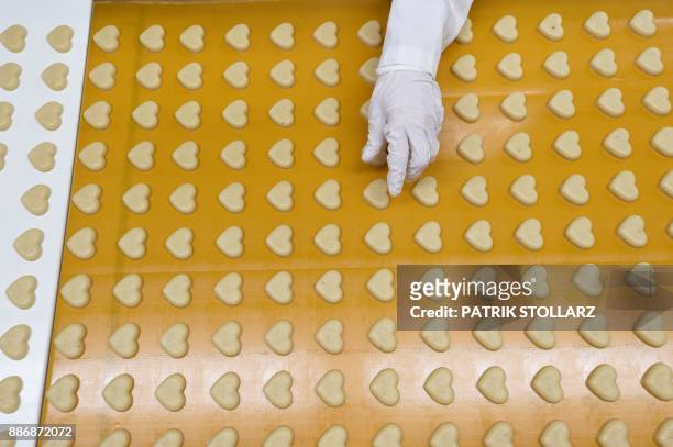 Heart-shaped marzipan pass along a conveyor belt at the headquarters of the traditional confectionary maker JG Niederegger GmbH in Luebeck, Germany,...