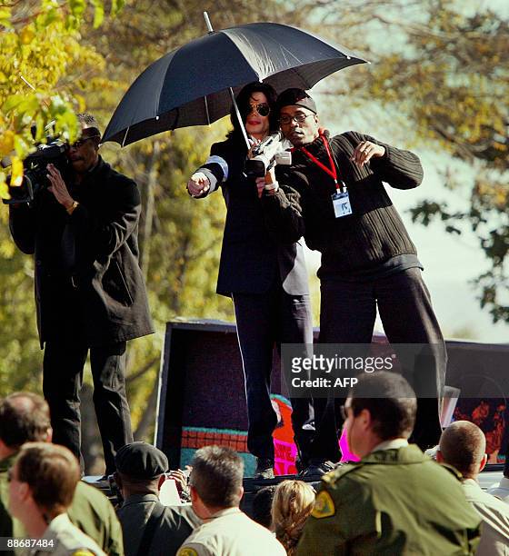 Photo dated January 16, 2004 shows US pop star Michael Jackson directing his videographers to photograph his fans as they stand on top of the...