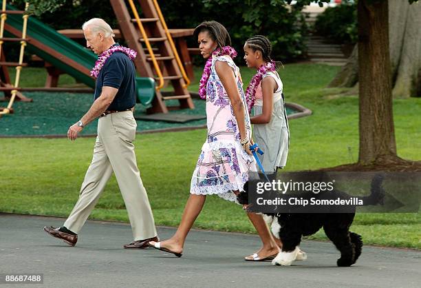 Vice President Joe Biden, first lady Michelle Obama, Malia Obama and family dog Bo arrive at a luau for members of Congress and their families on the...