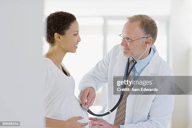 doctor giving pregnant woman check-up - doctor side view stock pictures, royalty-free photos & images