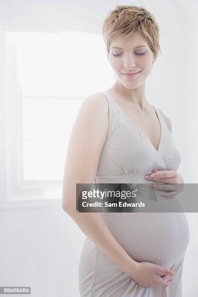 妊娠中のお腹を持つ女性 - pregnant redhead ストックフォトと画像