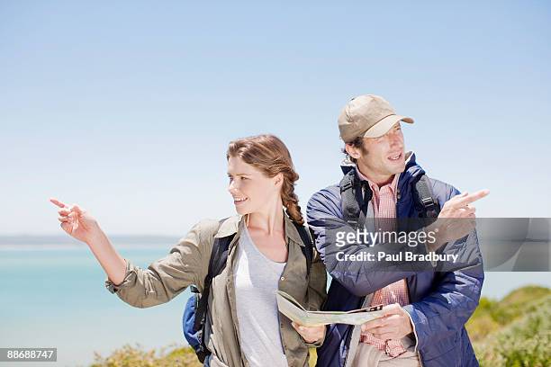 couple hiking in remote area and looking at map - opposite directions stock pictures, royalty-free photos & images