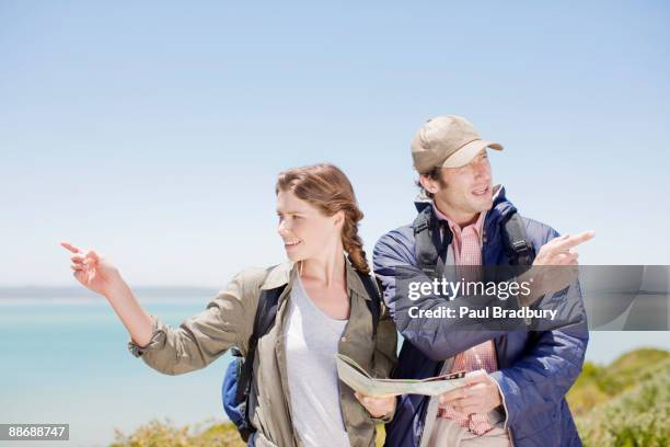 casal caminhadas em zonas remotas e olhando para o mapa - couple pointing imagens e fotografias de stock