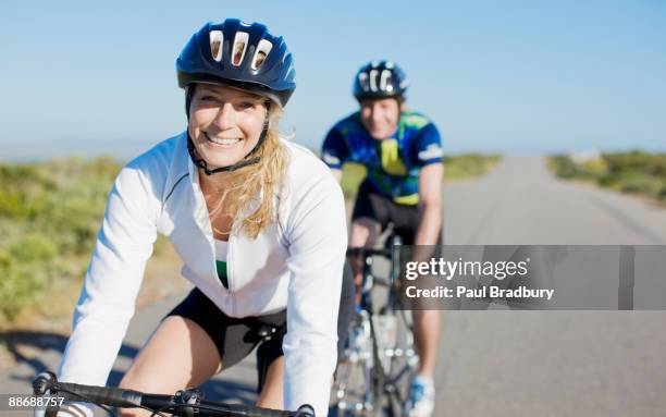 couple bike riding in remote area - women on bike stockfoto's en -beelden