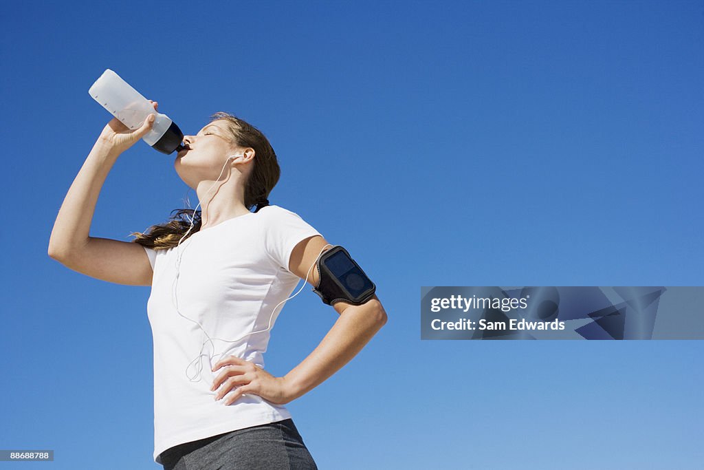 Woman runner drinking from water bottle