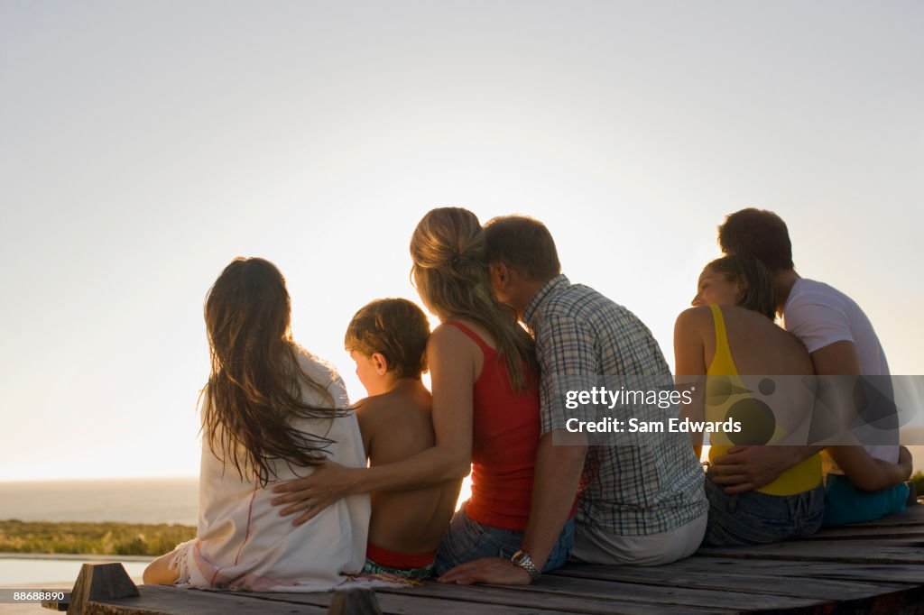 Family sitting on pier together