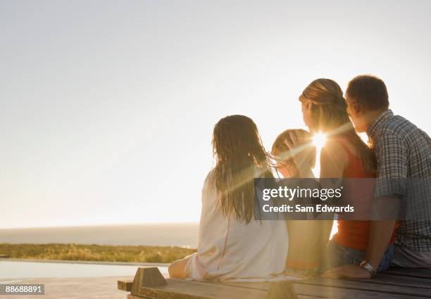 family sitting on deck in afternoon sun - kid leaning stock pictures, royalty-free photos & images