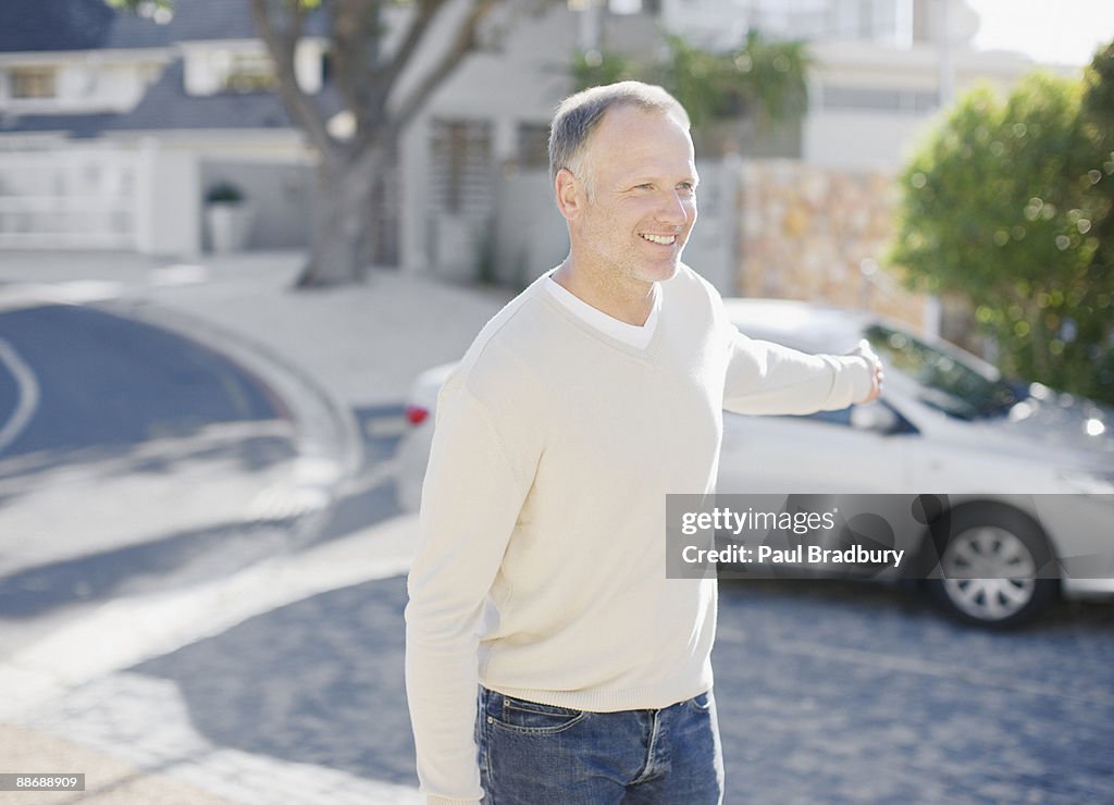 Man using keyless lock on car in driveway