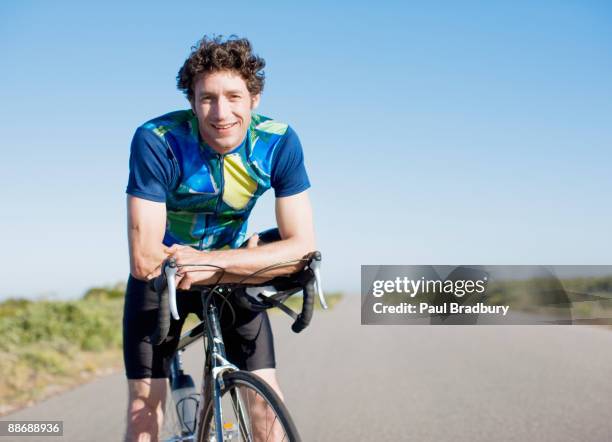 bike rider resting on bicycle in remote area - mid adult stock pictures, royalty-free photos & images