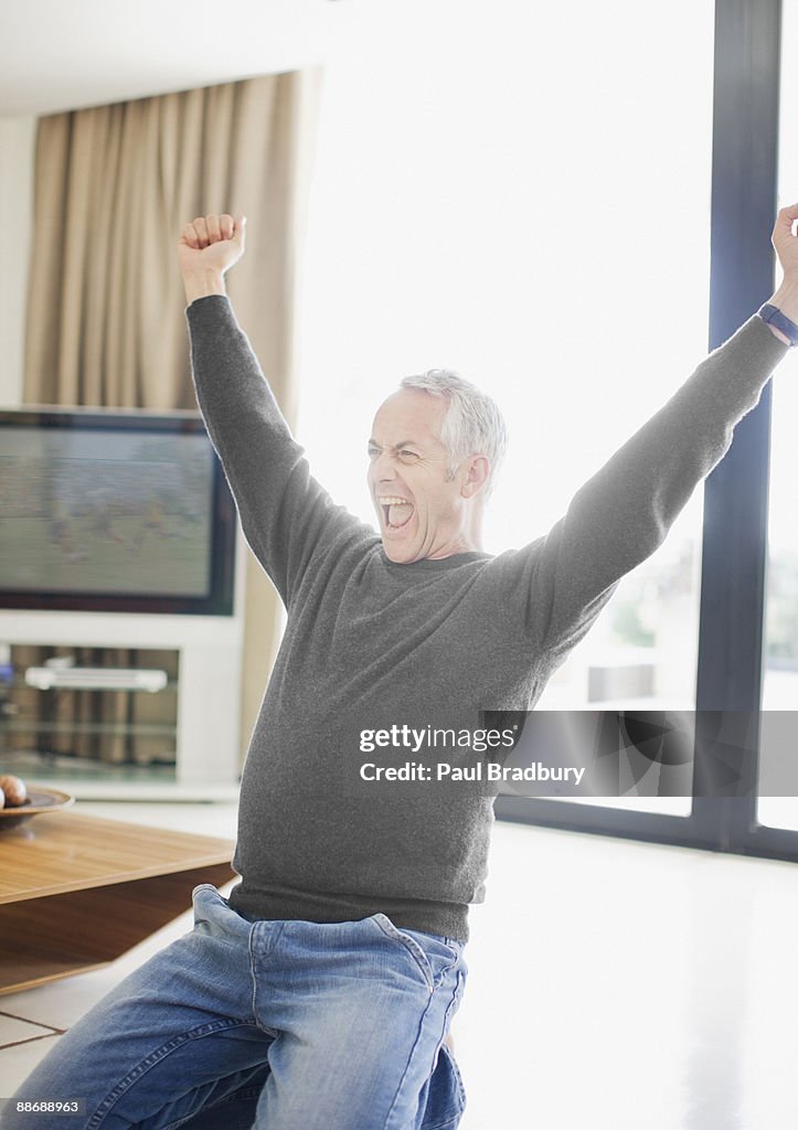 Man shouting with excitement in living room
