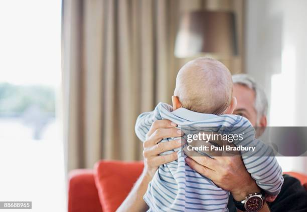 man lifting baby - grandparents raising grandchildren stock pictures, royalty-free photos & images