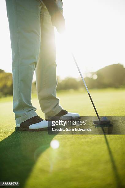 man using putter to play golf - golf club stock pictures, royalty-free photos & images