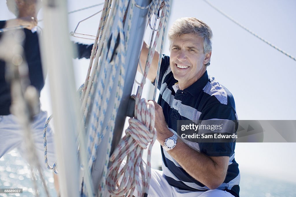 Man squatting on sailboat