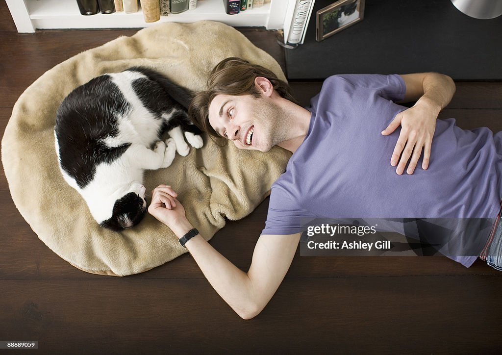 Man laying on floor with cat
