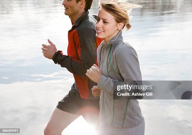 couple jogging near pond - ashley cooper - fotografias e filmes do acervo