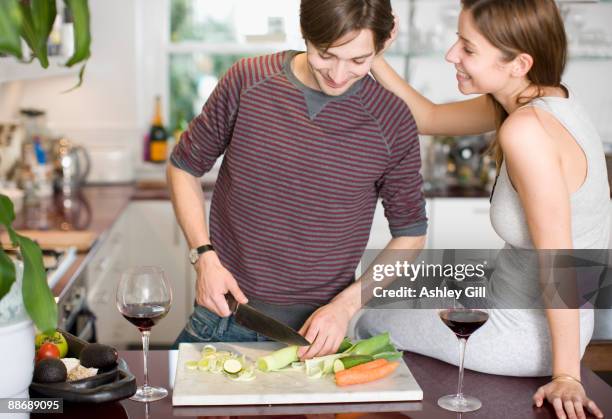 couple preparing dinner in kitchen - chopped cucumber stock pictures, royalty-free photos & images