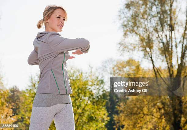 woman stretching in park - warm up exercise stock pictures, royalty-free photos & images
