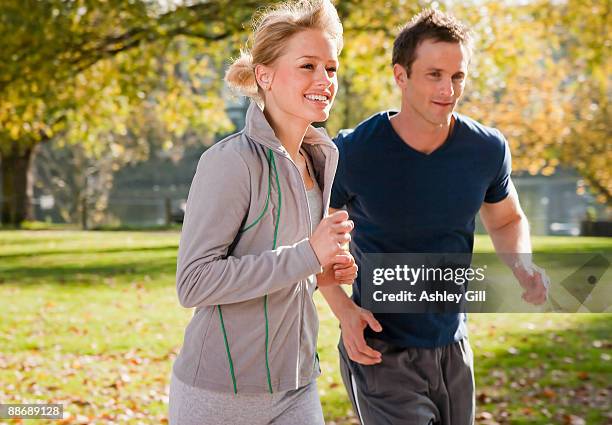 couple jogging in park in autumn - ashley cooper - fotografias e filmes do acervo