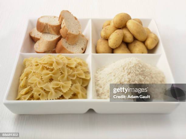 close up of sectioned plate with bread, potatoes, rice and pasta - carbohidrato fotografías e imágenes de stock