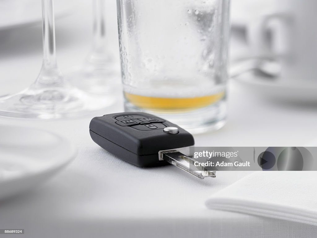 Close up of remote entry car key on restaurant table next to empty beer glass