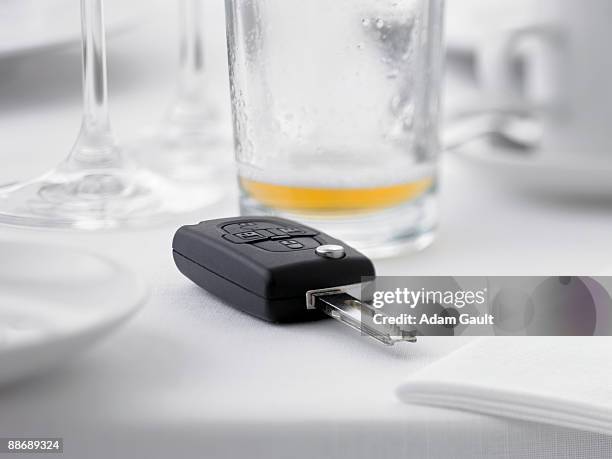 close up of remote entry car key on restaurant table next to empty beer glass - car keys table stock pictures, royalty-free photos & images