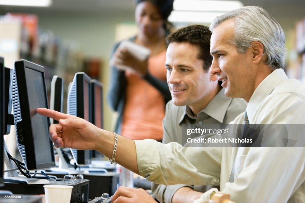 Businessmen looking at computer monitor