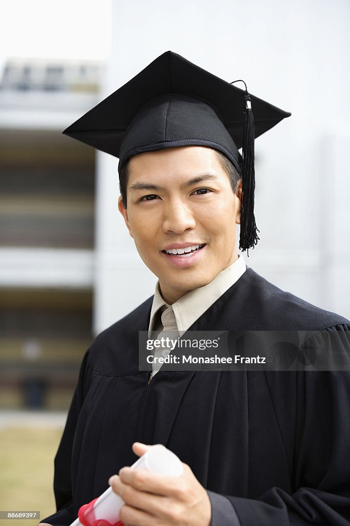 Man In Graduation Cap And Gown Holding Diploma High-Res Stock Photo ...