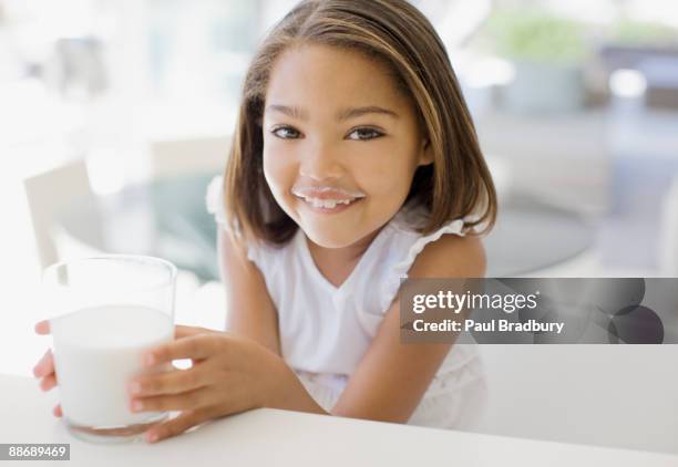 mädchen trinkt ein glas milch - milk moustache stock-fotos und bilder