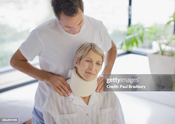 marido ayudar a su esposa en collarín médico - collarín médico fotografías e imágenes de stock