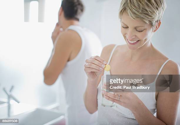 woman taking pill in the morning - effervescent tablet stock pictures, royalty-free photos & images