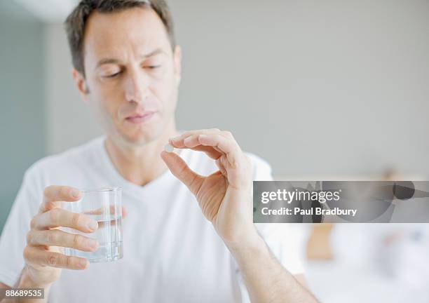 man taking medicine - pijnstiller stockfoto's en -beelden