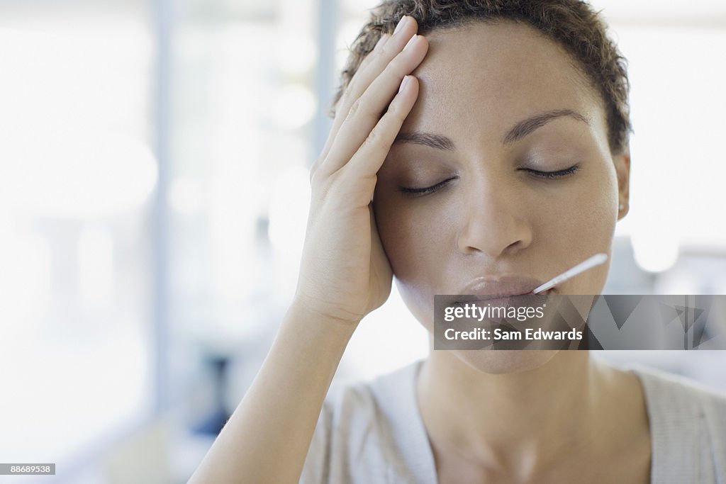Sick woman taking her temperature