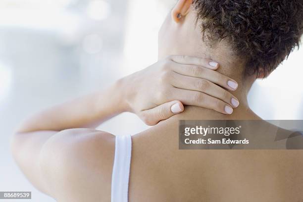 woman rubbing sore neck - neckache stock pictures, royalty-free photos & images