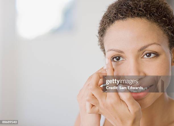 woman inserting contact lens - contact lens stock pictures, royalty-free photos & images